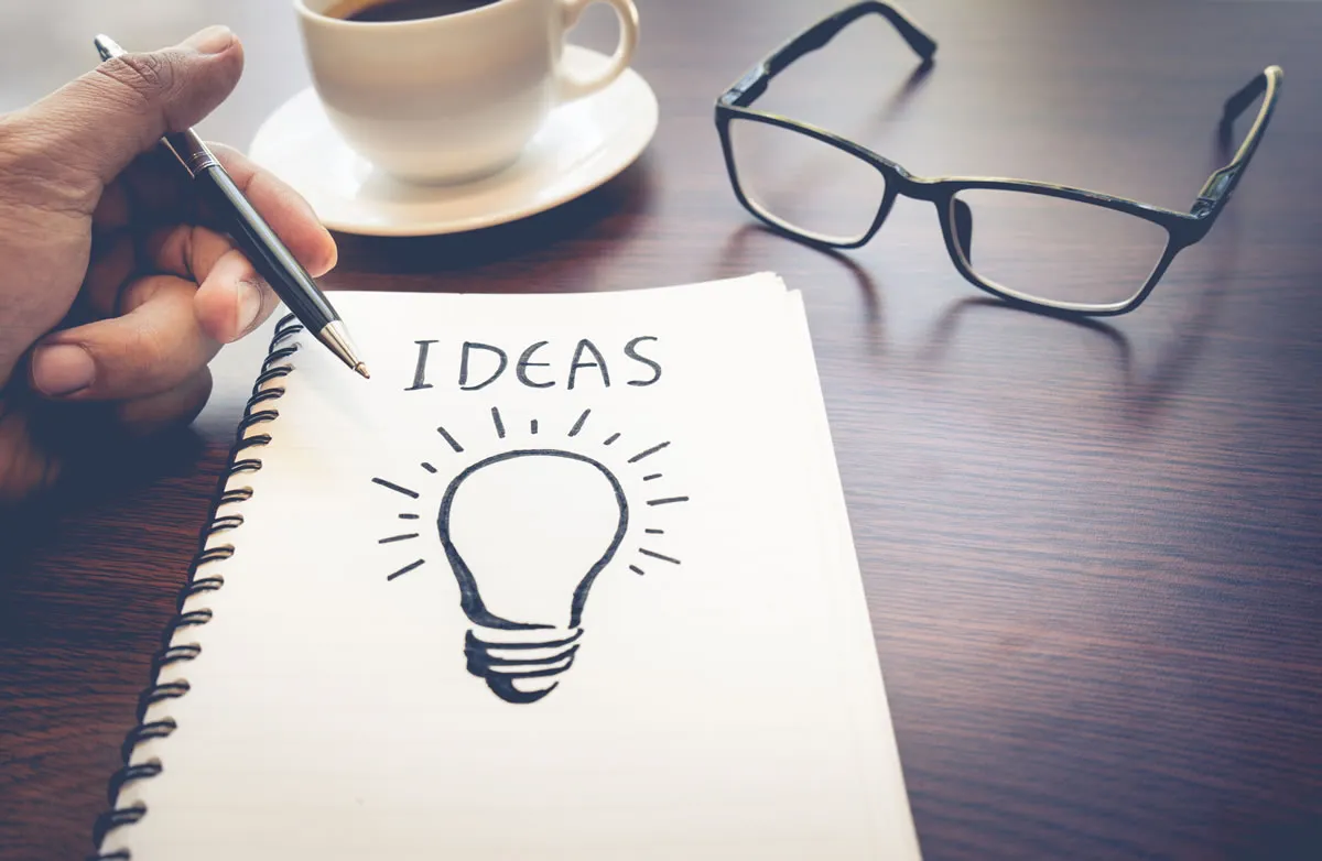 Caderno com a palavra ideias, representando a criação de conteúdo para o blog